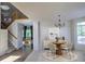 Cozy living room with elegant chandelier, dining table, and staircase in view at 331 Las Lomas St, Brighton, CO 80601