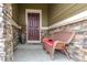 Covered front porch with a wood chair and a decorative vase sitting next to the front door at 3936 Costillo Ct, Brighton, CO 80601
