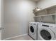 Practical laundry room with modern Whirlpool washer and dryer, plus storage shelves at 3936 Costillo Ct, Brighton, CO 80601