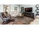 Living room featuring hardwood floors, modern entertainment center with fireplace and comfortable furniture at 3936 Costillo Ct, Brighton, CO 80601