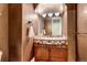 Charming powder room with wood vanity, tile backsplash, and decorative lighting at 9132 Scenic Pine Dr, Parker, CO 80134