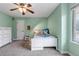 Cozy bedroom with a white bed frame, a large window, a ceiling fan, and light green walls at 9132 Scenic Pine Dr, Parker, CO 80134