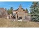 Back exterior view of the home showcases a stone foundation and an upper level deck at 9132 Scenic Pine Dr, Parker, CO 80134