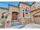 Gorgeous home entrance with a beautiful solid wood door, stone accents, and well-manicured landscaping at 9132 Scenic Pine Dr, Parker, CO 80134