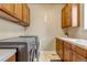 Efficient laundry room with wooden cabinets, countertop space, and modern washer/dryer units at 9132 Scenic Pine Dr, Parker, CO 80134