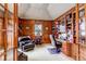 Executive office with wood paneled walls, custom built-ins, and ample natural light at 9132 Scenic Pine Dr, Parker, CO 80134