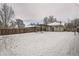 Winter backyard featuring a snowy yard, wooden fence, and home with a covered patio at 3515 N Elizabeth St, Denver, CO 80205