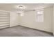 Bright finished basement space with neutral carpet, bright walls, and built-in shelves for storage and display at 3515 N Elizabeth St, Denver, CO 80205