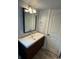 Bright bathroom featuring a modern vanity, sleek faucet, and updated lighting fixture above the mirror at 915 N Irving St, Denver, CO 80204