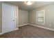 Cozy bedroom with neutral carpet, fresh paint, a window, and a white door at 915 N Irving St, Denver, CO 80204