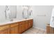 Bathroom with double vanity sinks and neutral-toned tile floors at 14794 Vine St, Thornton, CO 80602