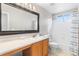 Bathroom with a large mirror and shower/tub with blue-patterned curtain at 14794 Vine St, Thornton, CO 80602