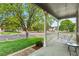 Relaxing covered front porch with a swing, offering a view of the street and a lush green lawn at 14794 Vine St, Thornton, CO 80602