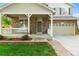 Close up of home exterior with a stone facade, covered porch, and beautifully landscaped front yard at 14794 Vine St, Thornton, CO 80602