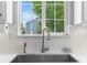 Kitchen sink with subway tile, modern faucet, and backyard view at 14794 Vine St, Thornton, CO 80602
