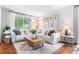 Cozy living room with a large sectional sofa, decorative rug, and an abundance of natural light from the large window at 14794 Vine St, Thornton, CO 80602