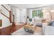 Cozy living room boasts hardwood floors, a modern coffee table, and staircase to the upper level at 14794 Vine St, Thornton, CO 80602