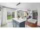 Open floorplan with island seating, hardwood floors, fireplace, and sliding glass doors leading to patio at 14794 Vine St, Thornton, CO 80602