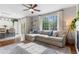 Bright living room features a large sectional sofa, hardwood floors, and natural light from the large windows at 14794 Vine St, Thornton, CO 80602