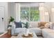 Bright and inviting living room showcasing a large window, hardwood floors, and a comfortable sectional sofa at 14794 Vine St, Thornton, CO 80602