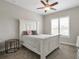 Bedroom featuring a white wood-framed bed, ceiling fan, and shuttered window overlooking neighborhood at 10111 Inverness Main St # 301, Englewood, CO 80112