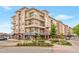 Beautiful exterior view of a multi-story condo building with retail space, lush landscaping, and outdoor seating at 10111 Inverness Main St # 301, Englewood, CO 80112
