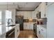 Modern kitchen featuring white cabinets, stainless appliances, gray backsplash, quartz counters and hardwood floors at 10111 Inverness Main St # 301, Englewood, CO 80112