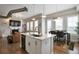 Modern kitchen with white cabinets, quartz countertops, island, and stainless steel appliances open to the dining and living area at 10111 Inverness Main St # 301, Englewood, CO 80112