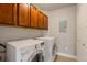 Convenient laundry area with side-by-side washer and dryer, ample storage, and tiled floor at 10111 Inverness Main St # 301, Englewood, CO 80112