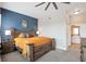 Bedroom featuring a wood-framed bed, ceiling fan, and shuttered windows with a view to an ensuite bathroom at 10111 Inverness Main St # 301, Englewood, CO 80112