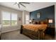 Bedroom featuring a wood-framed bed, ceiling fan, and shuttered windows overlooking neighborhood at 10111 Inverness Main St # 301, Englewood, CO 80112