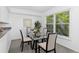 Bright dining area with a glass table, four chairs, and a large window at 221 S Garfield St # 213, Denver, CO 80209