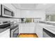 Bright kitchen with stainless steel appliances, white cabinetry, and tiled backsplash at 221 S Garfield St # 213, Denver, CO 80209