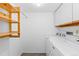 Neat laundry room equipped with a washer, dryer, and storage shelves at 221 S Garfield St # 213, Denver, CO 80209