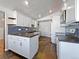 Modern kitchen with white cabinets, stainless steel appliances, and dark countertops at 1341 Sharpe Pl, Longmont, CO 80501