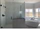 Bright bathroom with a glass shower, marble tile, and a soaking tub by a window at 270 High Meadows Loop, Elizabeth, CO 80107