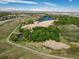 Scenic aerial view featuring a pond, walking path, and lush green spaces, perfect for outdoor enjoyment at 11033 E 28Th Pl, Denver, CO 80238