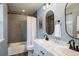 Well-lit bathroom featuring double vanity, modern fixtures, and a tiled shower at 11033 E 28Th Pl, Denver, CO 80238