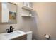 Cozy half bathroom featuring floating shelves, modern fixtures, and decorative artwork at 11033 E 28Th Pl, Denver, CO 80238