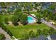Aerial view of a community pool surrounded by green spaces, trees, and charming neighborhood homes at 11033 E 28Th Pl, Denver, CO 80238
