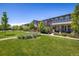 A row of townhomes overlooks a well-manicured green space with mature trees and a walking path at 11033 E 28Th Pl, Denver, CO 80238