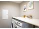 Functional laundry room with washer, dryer, and ample counter space at 11033 E 28Th Pl, Denver, CO 80238