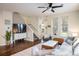 Open-concept living room with hardwood floors, a large TV, and plenty of natural light from the windows at 11033 E 28Th Pl, Denver, CO 80238