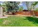 Spacious backyard features a lush lawn, a charming playhouse, and mature trees for outdoor enjoyment at 3090 S High St, Denver, CO 80210