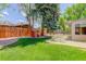Expansive backyard featuring mature trees, green grass, a playhouse, and outdoor seating for Gathering fun at 3090 S High St, Denver, CO 80210