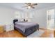 Bright bedroom featuring a plush bed, ample natural light, and hardwood floors at 3090 S High St, Denver, CO 80210