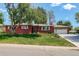 Charming brick ranch-style home with a well-manicured lawn and a two-car attached garage at 3090 S High St, Denver, CO 80210