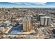 An aerial view shows the building situated in a vibrant city with snow-dusted rooftops and parking at 800 N Pearl St # 206, Denver, CO 80203