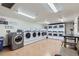Well-lit community laundry room equipped with multiple washers, dryers, folding tables, and seating at 800 N Pearl St # 206, Denver, CO 80203