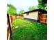 Spacious backyard with lush green grass, a classic brick house and wooden fencing at 1695 E Eastman Ave, Englewood, CO 80113